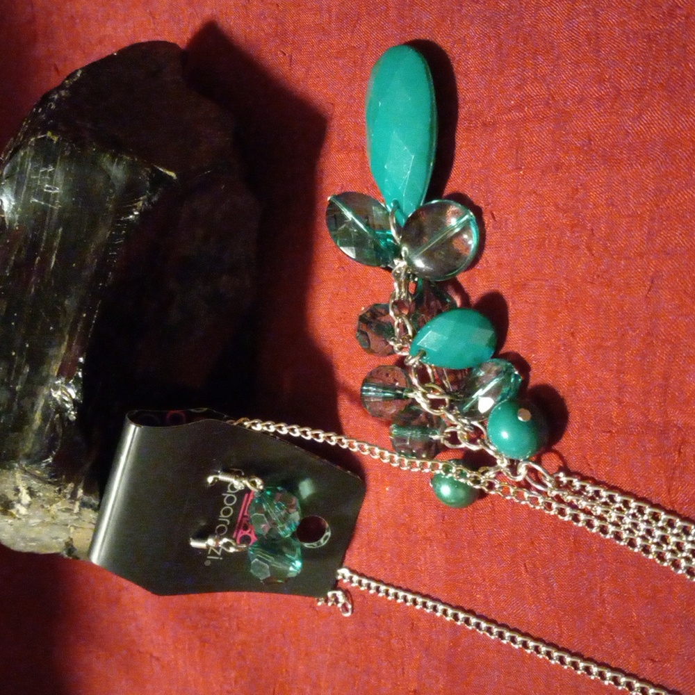 Matching necklace and earrings with emerald colored crystal cut resin gems.